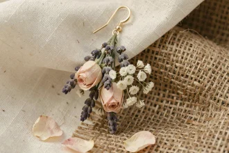 Boucle d'oreille pendante mariage en fleurs séchées lavande et rose sur fond lin crème