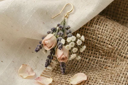 Boucle d'oreille pendante mariage en fleurs séchées lavande et rose sur fond lin crème